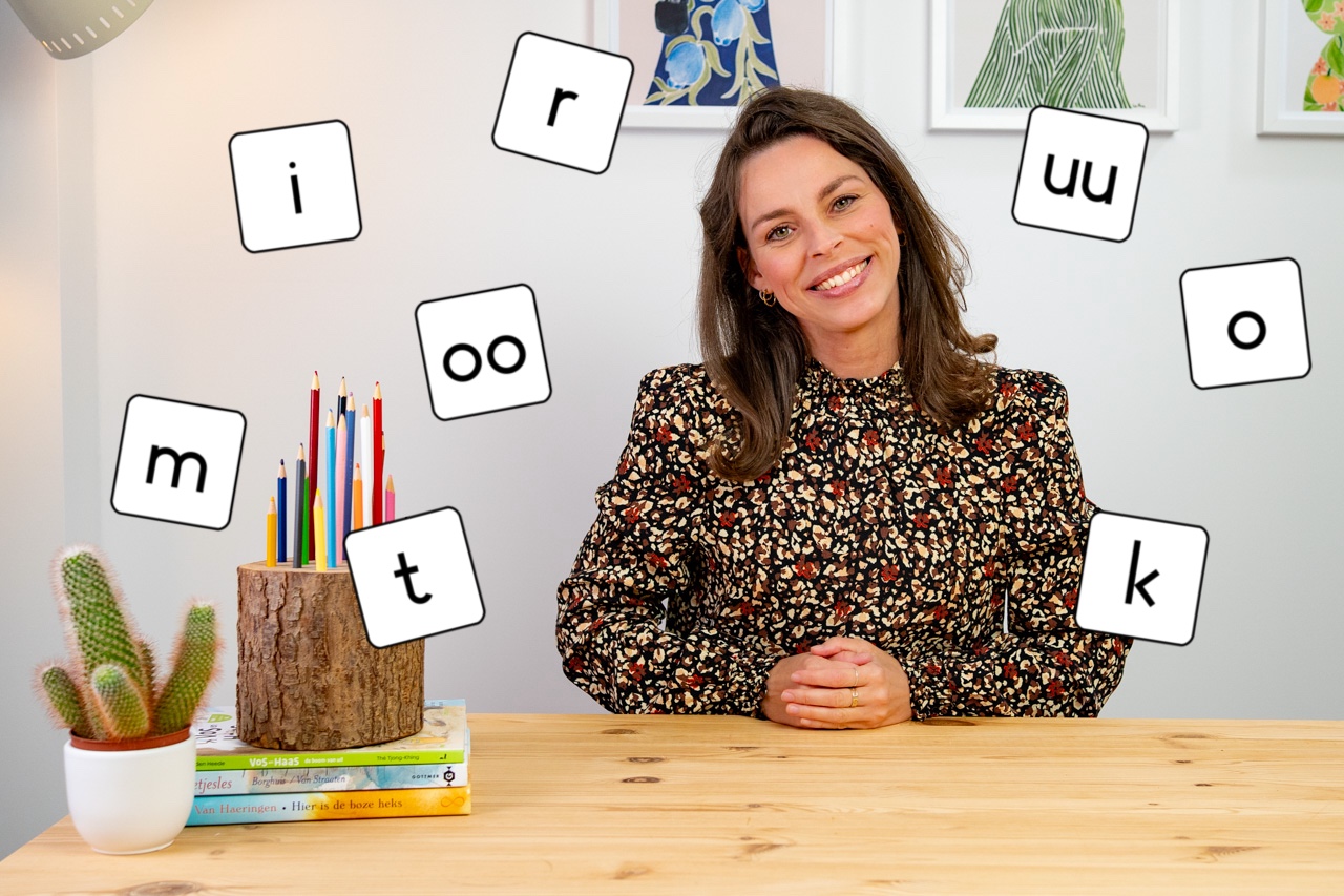 Anne tijdens een taalles, omringd door letters